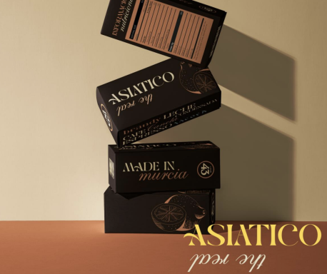 Tres cajas de producto Asiatico apiladas sobre una superficie naranja.